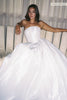 A woman wearing a strapless white ballgown with a structured bodice and voluminous taffeta skirt