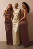 Three women modeling floor-length satin bridesmaid dresses in brown, cream, and dusty rose tones against a plain beige wall.