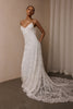 woman wearing a white lace backless dress with thin straps and delicate chain jewellery across her back