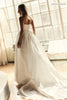 A woman wearing a strapless white wedding gown with a fitted bodice and full flowing skirt