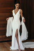 Woman wearing a white wedding dress with a deep neckline and slit and a white shawl