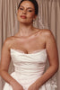 Bride wearing a strapless wedding dress with lace details and pearl earrings