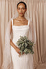 A bride wearing a crepe wedding dress and tulle drop veil
